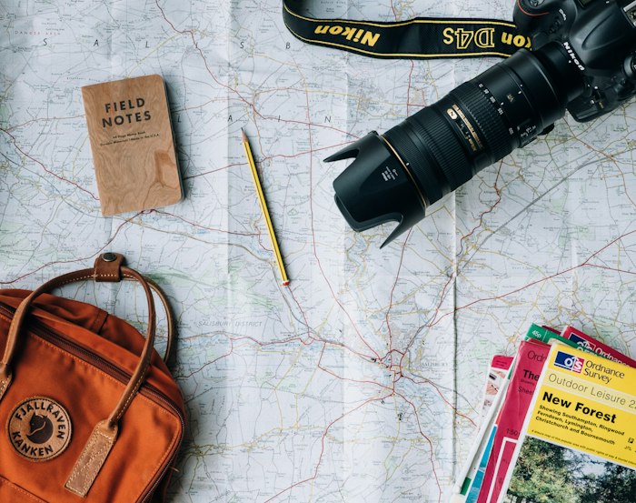 Travel planning with a map, camera and notebook
